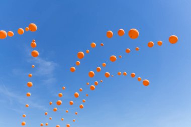 Mavi gökyüzünde turuncu balonlar