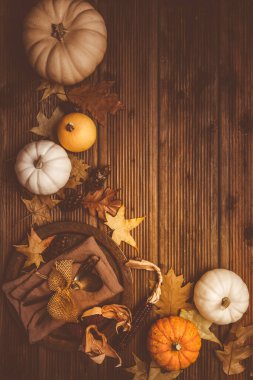 Autumn background with pumpkins, cutlery and golden leaves on a wooden surface
