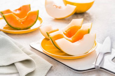 Fresh cantaloupe and lemon drop melon on cutting board - low calorie refreshment for hot summer
