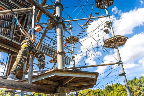 Child climbing in the high ropes course. Sport and adventure concept.