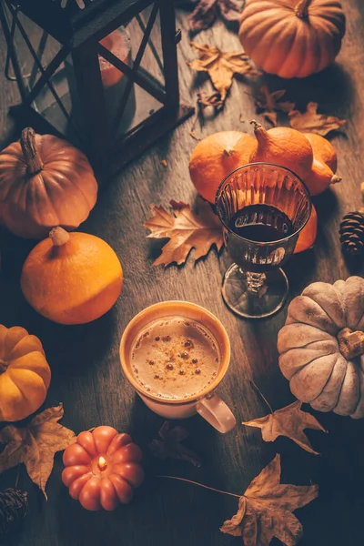 Cozy autumn composition. Hot cocoa  with autumn leaves and pumpkins  on kitchen table