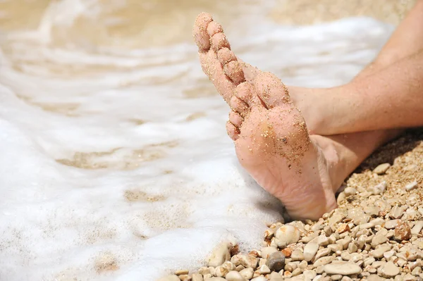 Relajación en la playa, detalle de los pies masculinos — Foto de Stock