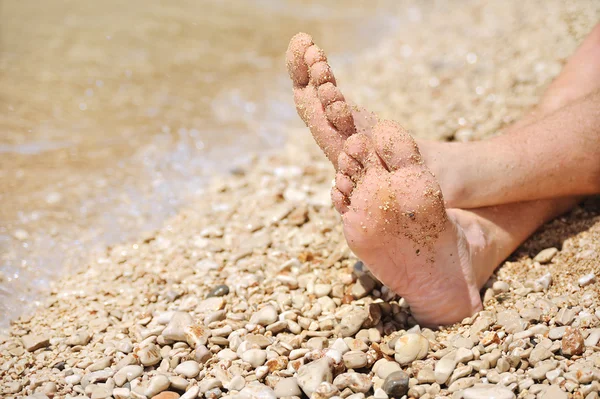 Relajación en la playa, detalle de los pies masculinos — Foto de Stock