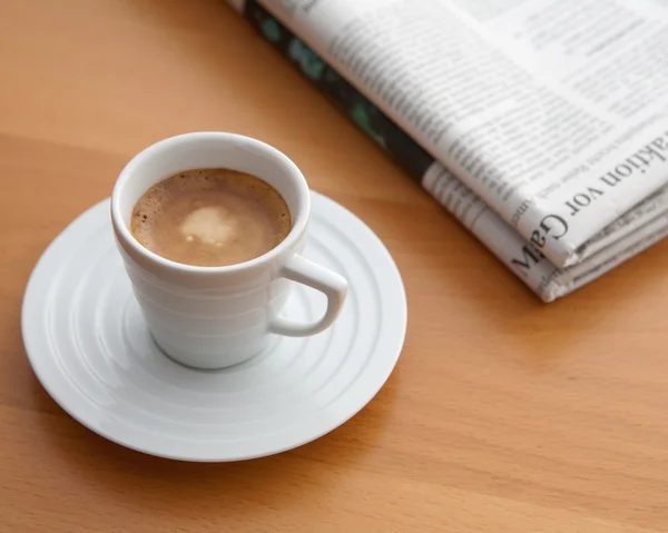 Espresso met krant op een tafel — Stockfoto