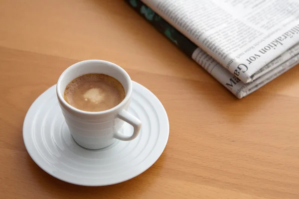 Espresso met krant op een tafel — Stockfoto