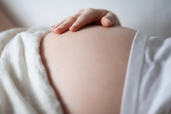 Pregnant woman holding her belly with her hand — Stock Photo, Image