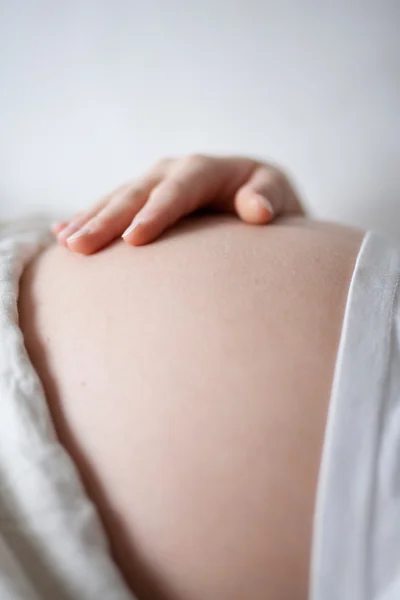 Pregnant woman holding her belly with her hand — Stock Photo, Image