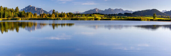 panoramic landscape in Bavaria with mountain range and lake