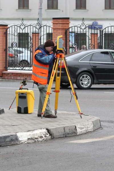 Der Arbeiter bedient einen Theodolit — Stockfoto