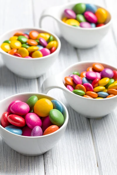Kolorowe cukierki w misce biały — Zdjęcie stockowe