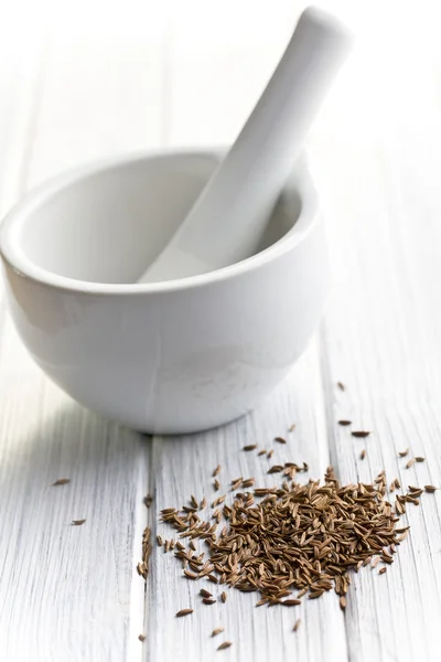 Cumin seeds and ceramic mortar — Stock Photo, Image