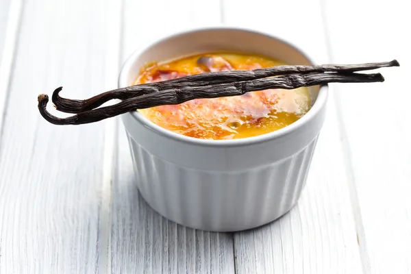 Creme brulee in ceramic bowl with vanilla pod — Stock Photo, Image