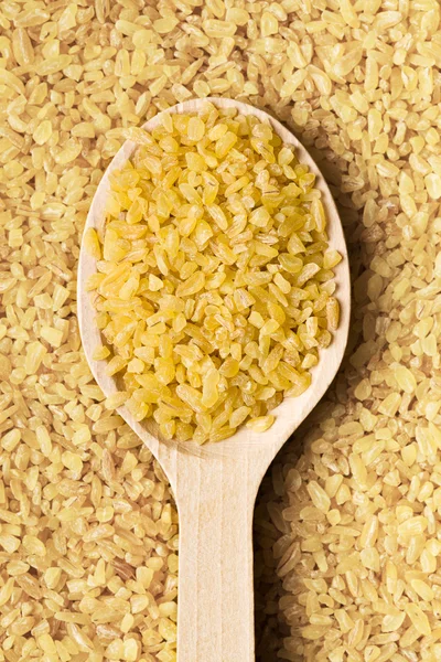 Trigo bulgur en cuchara de madera — Foto de Stock