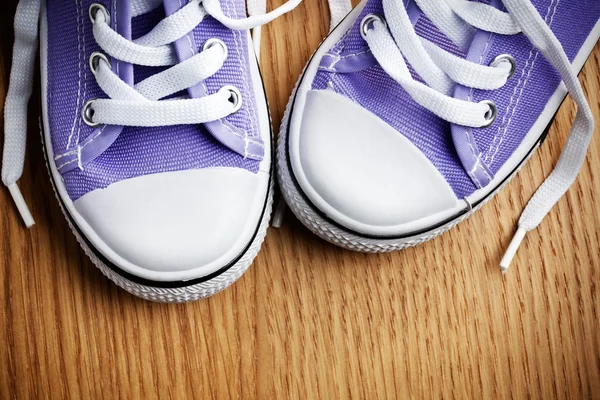 Colorful sneakers on wooden floor — Stock Photo, Image