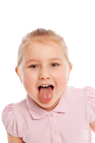 Liten flicka stående sticker ut tungan — Stockfoto