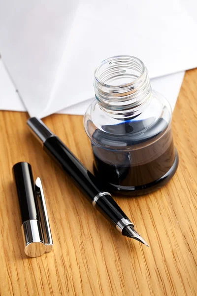 Caneta-tinteiro e tinta na mesa — Fotografia de Stock