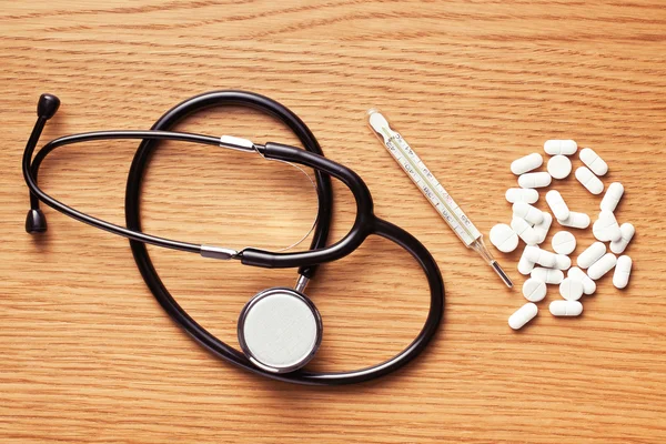 Białe tabletki z stetoskop — Zdjęcie stockowe