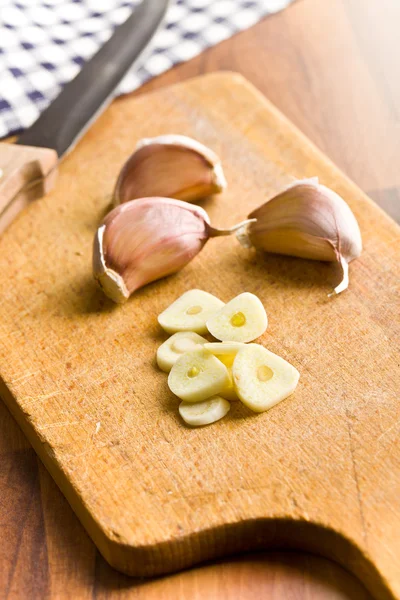 Sliced garlic on kitchen table — Stock Photo, Image