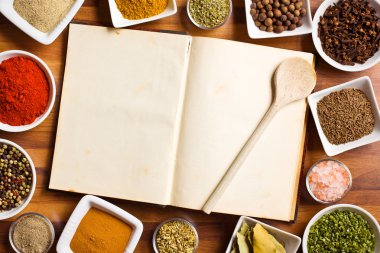 Cookbook and various spices and herbs. clipart