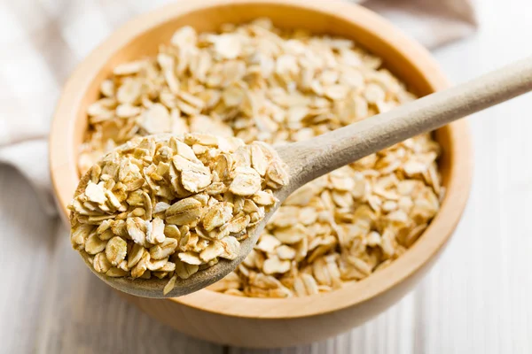 Oat flakes on a wooden spoon — Stock Photo, Image