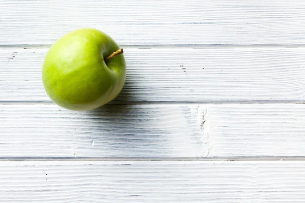 Green apple on white kitchen table — Stock Photo, Image