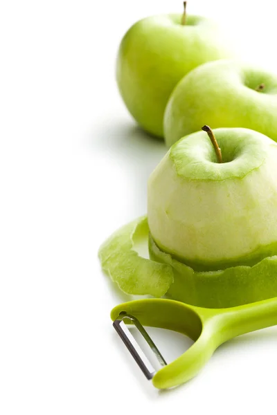 Peeled green apple with peeler — Stock Photo, Image