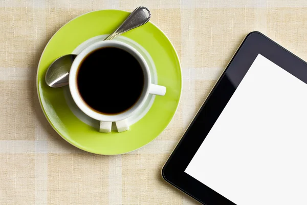 Zwarte koffie in groene beker met tablet-computer — Stockfoto