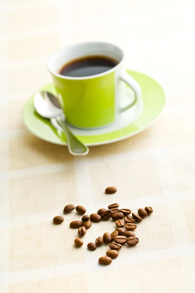 Кофейные зерна на ретро скатерти — стоковое фото