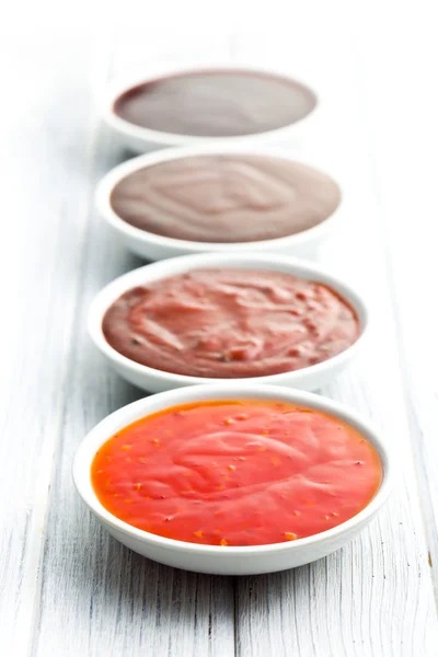 Различные соусы для барбекю в керамических мисках — стоковое фото