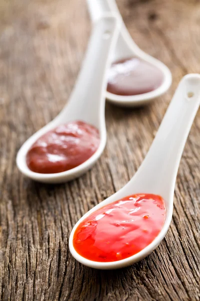 Various barbecue sauces in ceramic spoons Stock Picture
