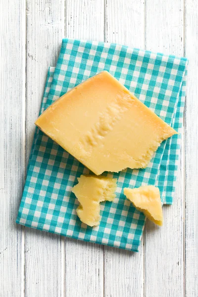Pieces of Italian hard cheese on a wooden table — Stock Photo, Image