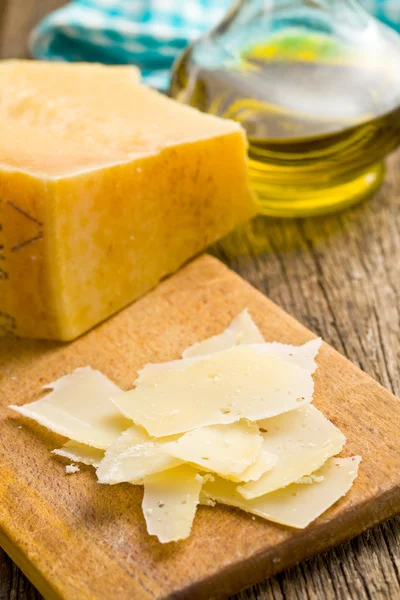Pezzi di formaggio a pasta dura italiano su un tavolo di legno — Foto Stock