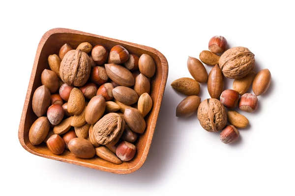 Различные неочищенные орехи в деревянной чаше — стоковое фото