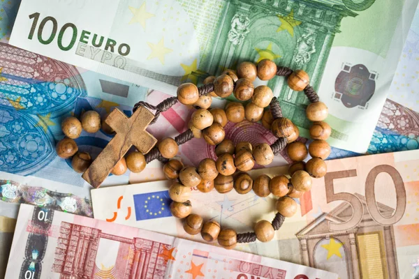 Rosary beads on euro bills — Stock Photo, Image