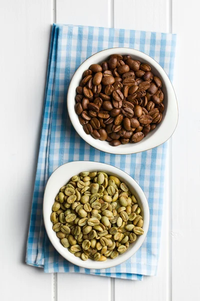 Roasted and unroasted coffee beans in ceramic bowls — Stock Photo, Image