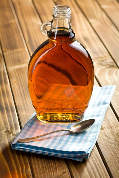 Кленовый сироп в стеклянной бутылке — стоковое фото