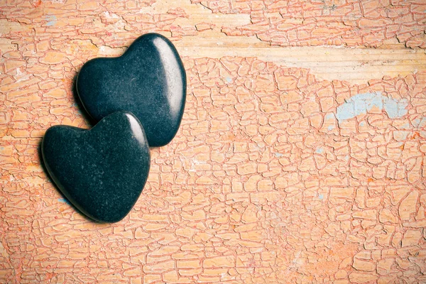 Corazones de piedra negra sobre fondo viejo agrietado —  Fotos de Stock