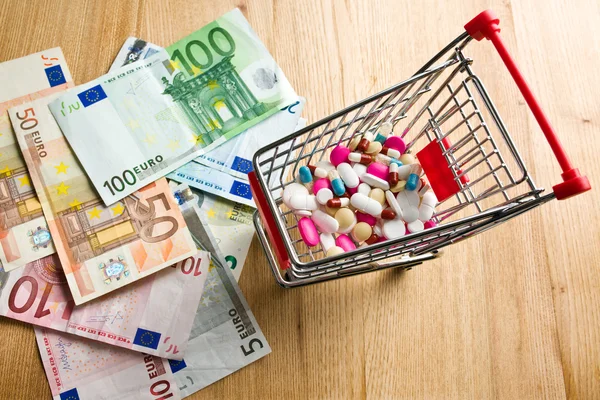 Pillen im Einkaufswagen und Dollars — Stockfoto