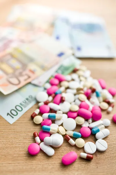 Barevné pilulky s euro bankovky — Stock fotografie