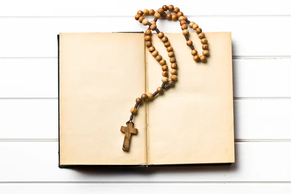 Wooden rosary beads with old book — Stock Photo, Image