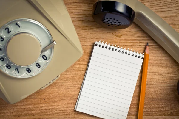 Vecchio telefono con notebook — Foto Stock