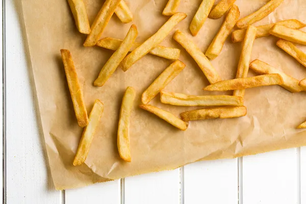 Batatas fritas em papel manteiga — Fotografia de Stock