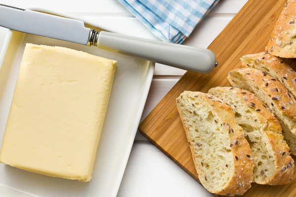 Kub av smör med skivat bröd — Stockfoto