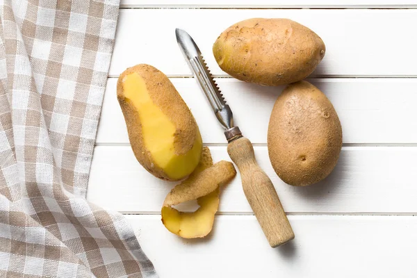 Pelador de madera y patatas — Foto de Stock