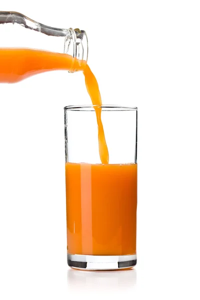 Gieten in glas wortelsap — Stockfoto