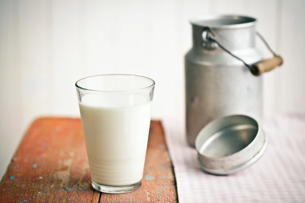 Milk in glass on old wooden table — Stock Photo, Image