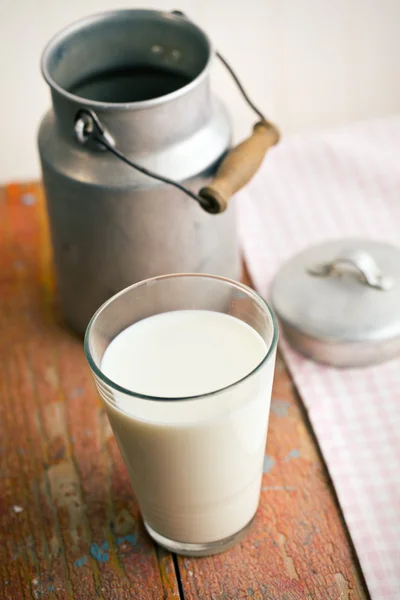 Milk in glass on old wooden table — Stock Photo, Image