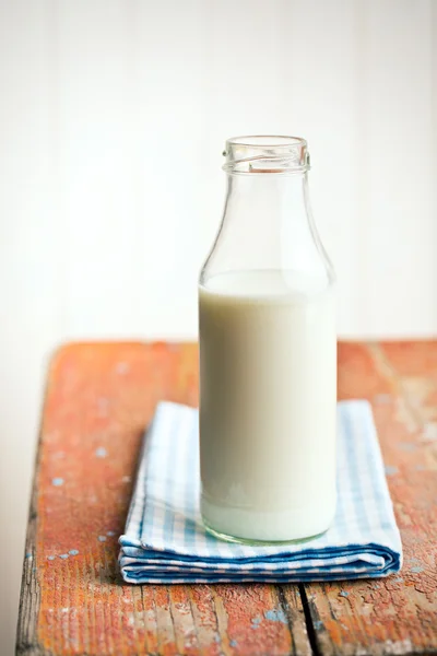 Melk in fles op oude houten tafel — Stockfoto