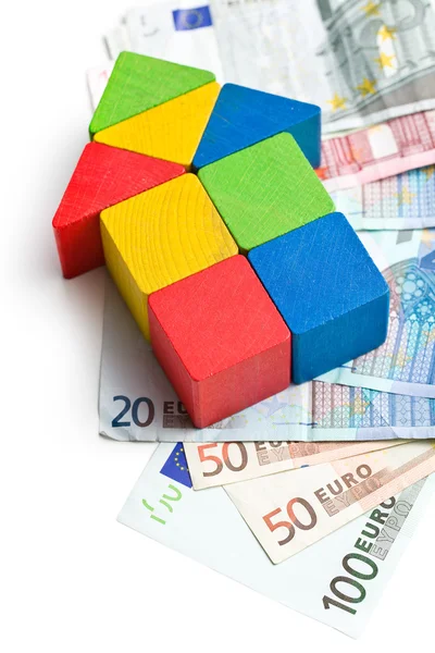 Casa feita de blocos de brinquedo de madeira com dinheiro euro — Fotografia de Stock