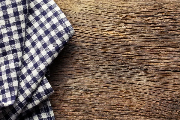 Geblokte servetten op oude houten tafel — Stockfoto